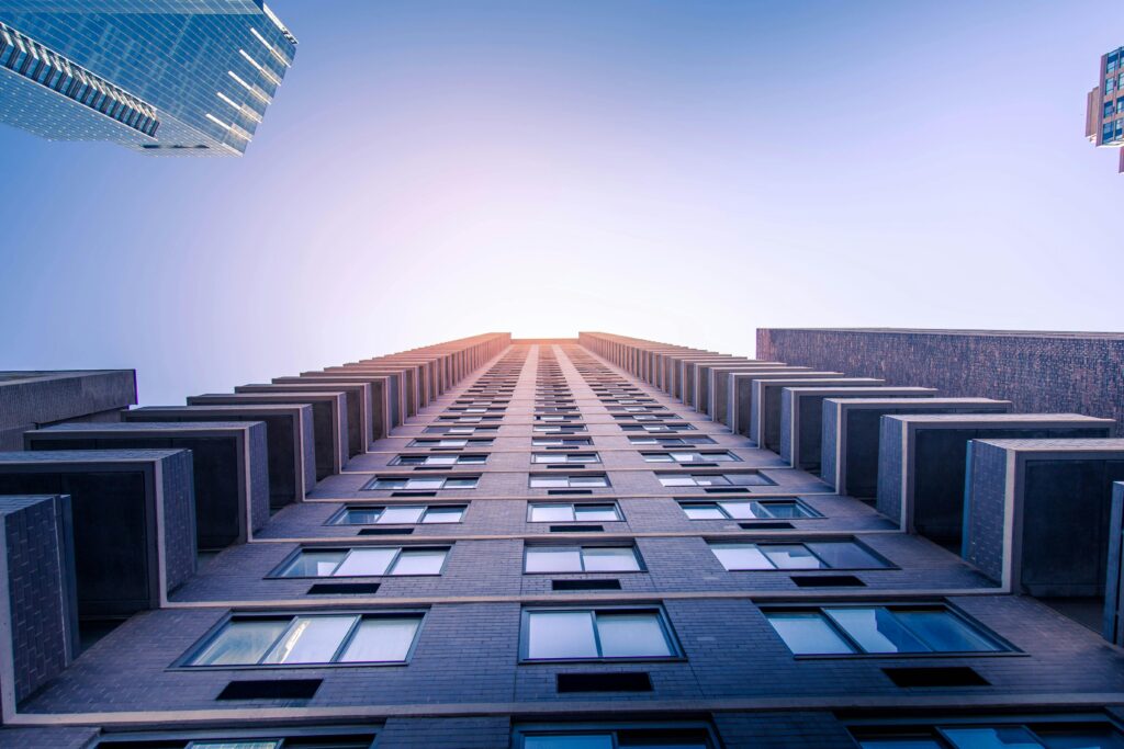 Dramatic low-angle view of modern skyscrapers with a clear sky backdrop, capturing urban architecture.