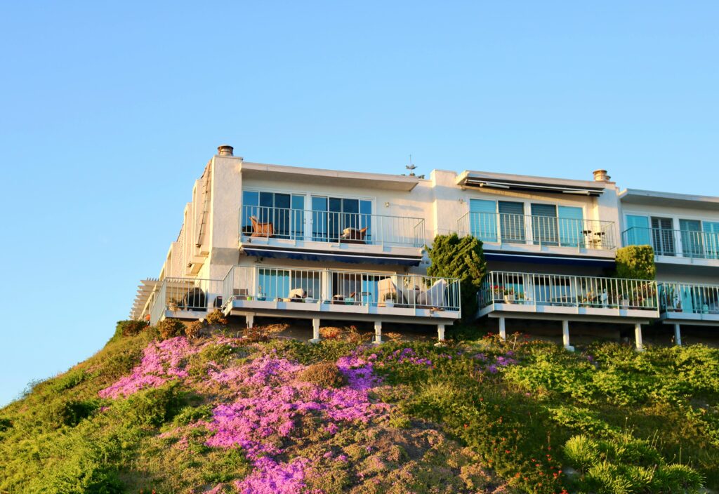 Modern coastal home perched on a California cliff with vibrant flowers and ocean views.