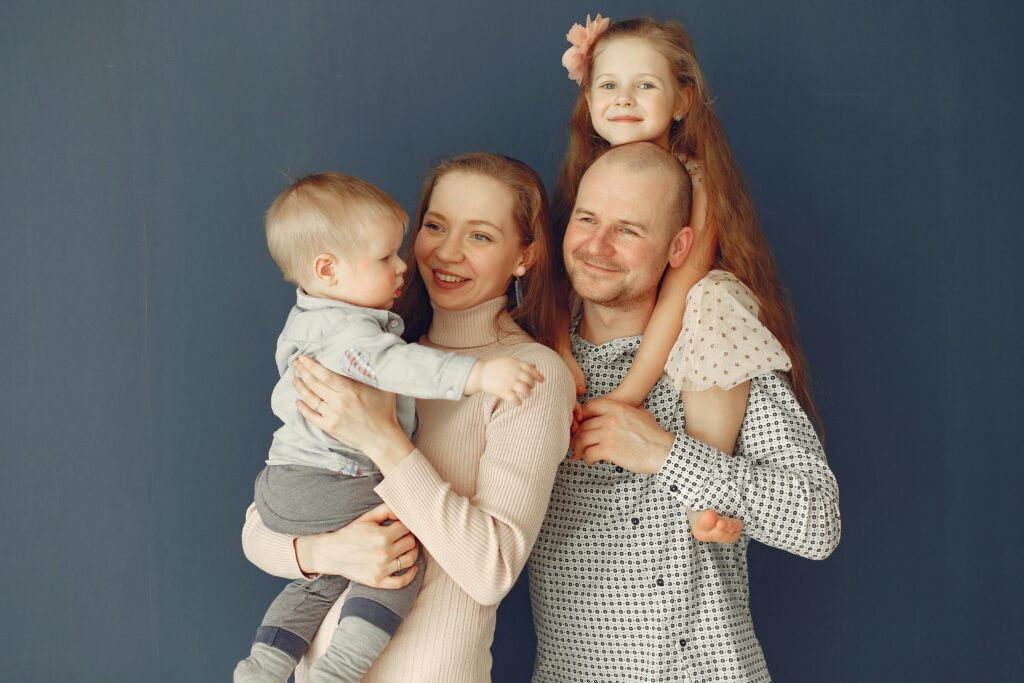 A joyful family portrait showcasing parents and their two children, expressing love and togetherness.