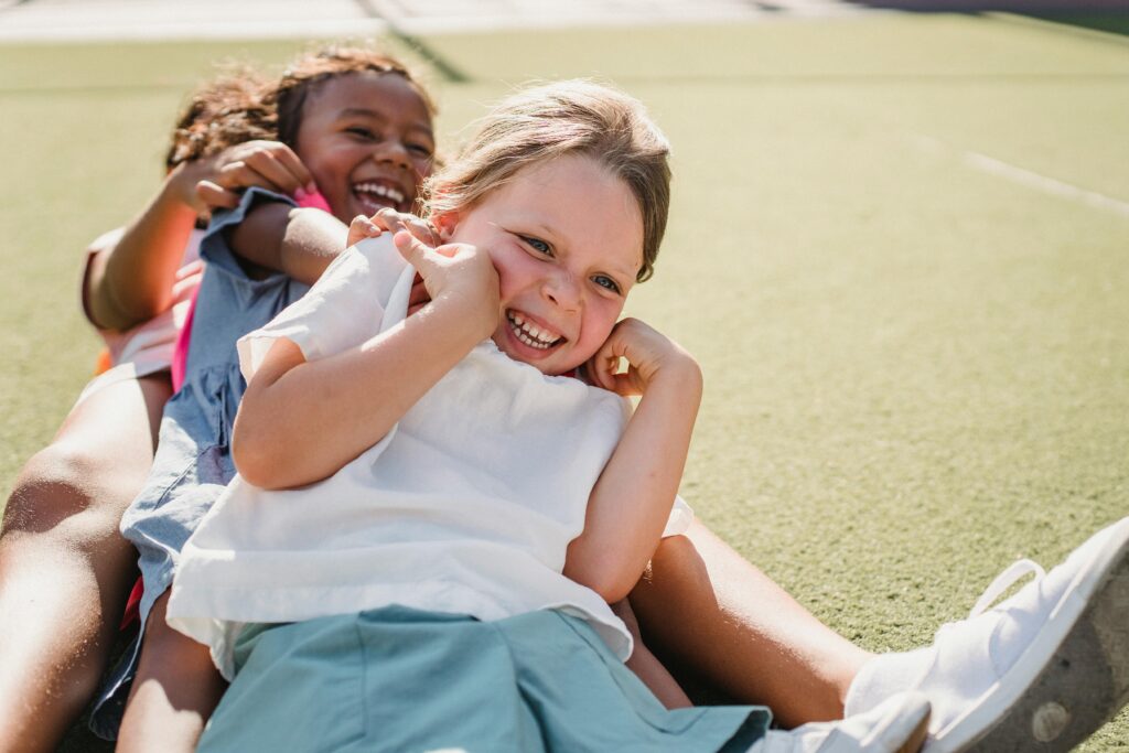 Joyful children smiling and playing on a sunny day outdoors.
