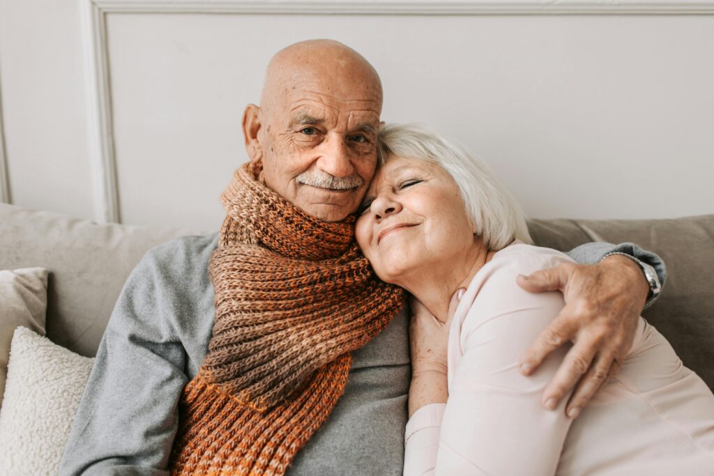 Heartwarming portrait of a senior couple sharing an affectionate embrace indoors.