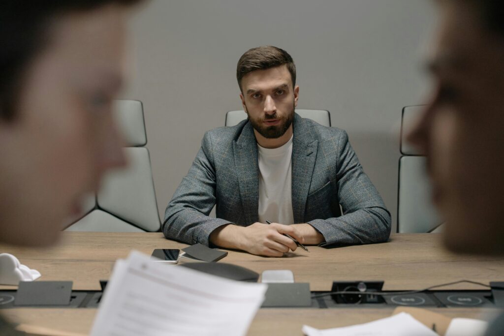 Serious businessmen engaged in a formal meeting around a conference table.
