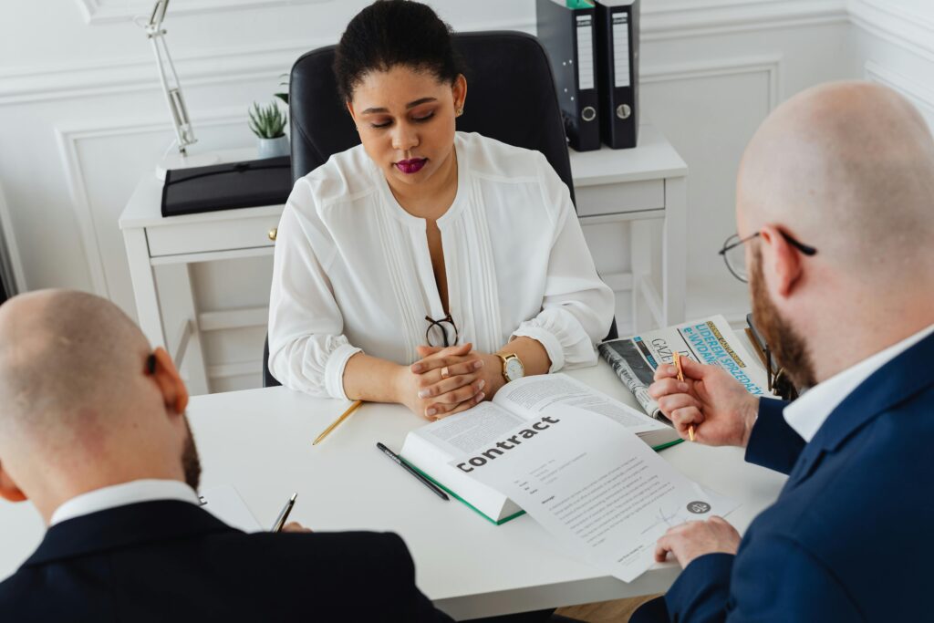 Professionals discuss a contract in a modern office setting, focusing on agreement details.