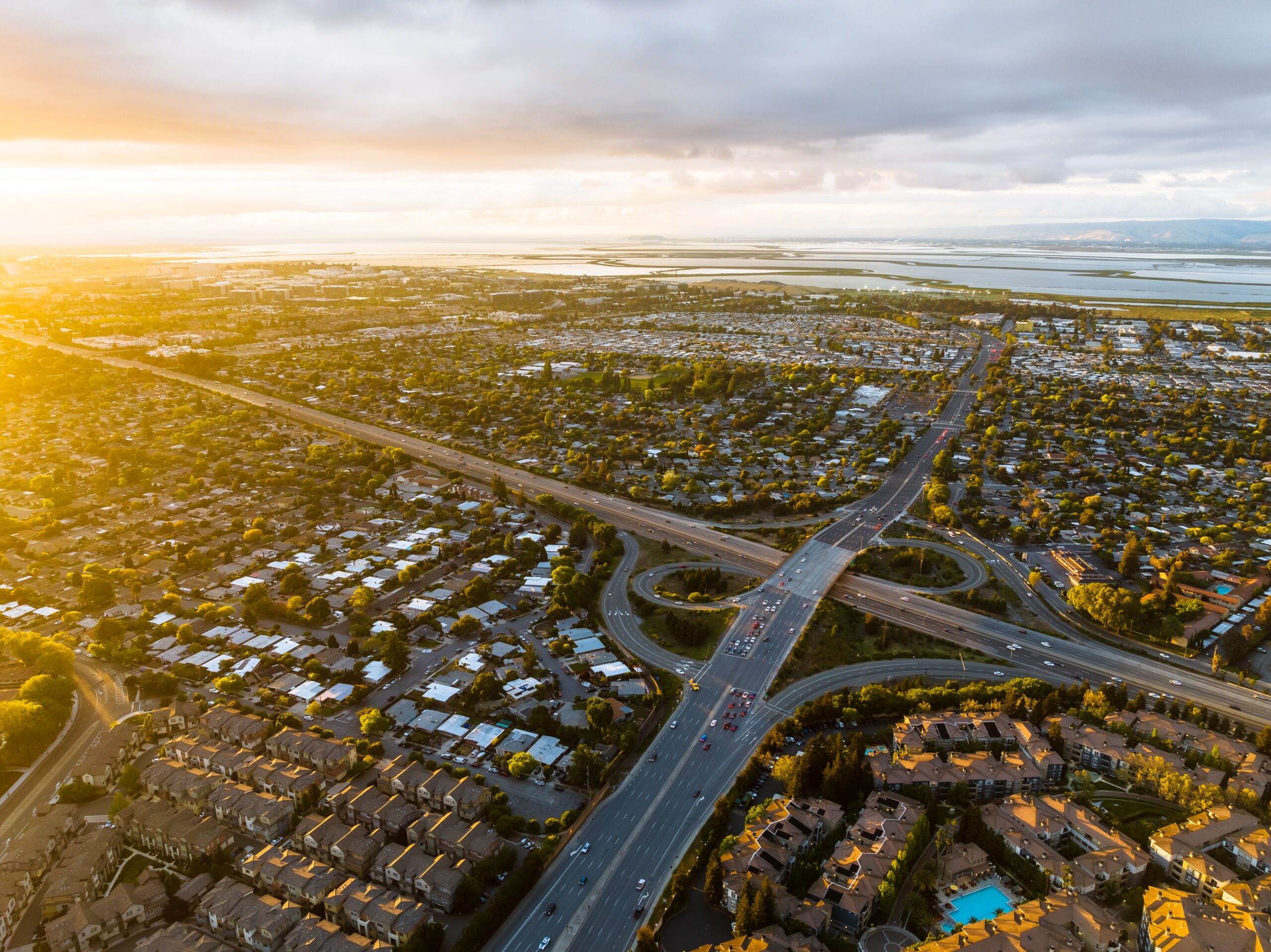 Sunset aerial view of a bustling urban intersection with surrounding residential areas.