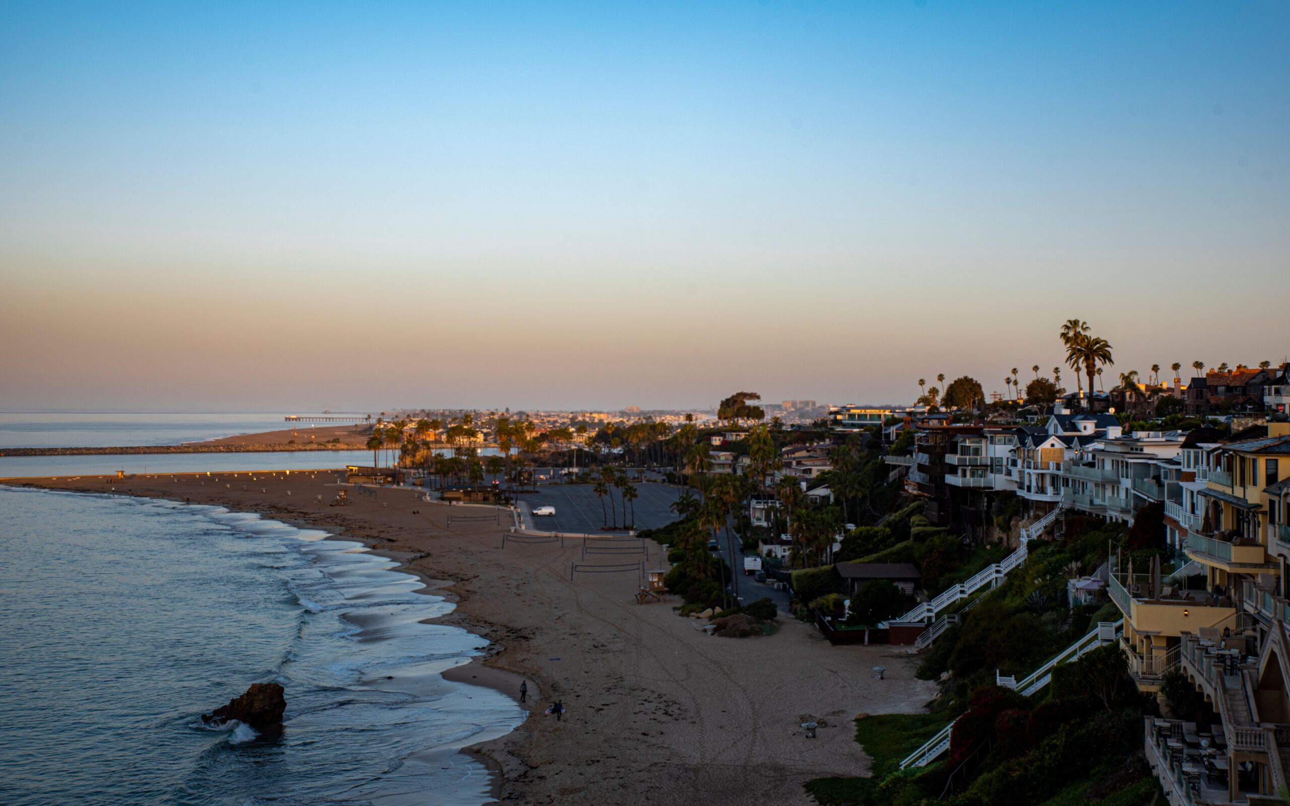 Scenic aerial shot capturing a coastal town and beach during sunset, showcasing stunning views.